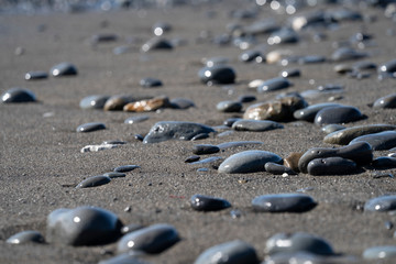 Steine am Strand, schwarzer Sandstrand