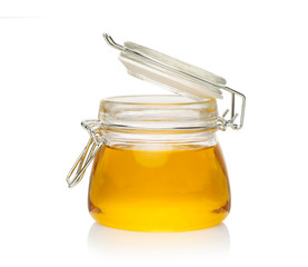 open glass jar with honey on a white background