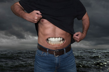 Strong man showing his belly with an open mouth showing his teeth