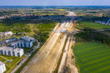 construction of new road at suburb area. aerial top view on industrial equipment and machinery working at city construction site
