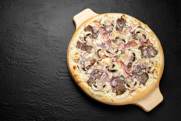 BBQ pizza on a black background, on a cream base in combination with mozzarella, veal BBQ, bacon,...