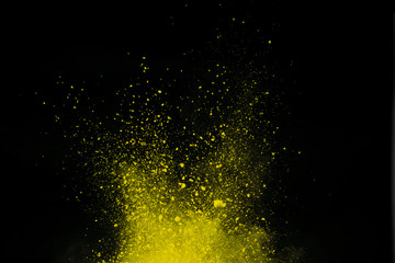 Yellow powder explosion on black background. Colored cloud. Colorful dust explode. Paint Holi.