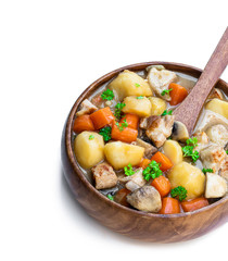 Stewed pork with vegetables in wooden bowl isolated on white