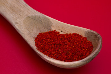 Piment d'espelette, baskisches Chili aus Gorria-Schoten, Gewürz mit milder Schärfe aus dem Baskenland, roter Hintergrund