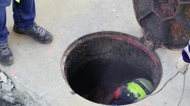 utility worker cleaning and repairing pipes inside the sewer , video hd footage
