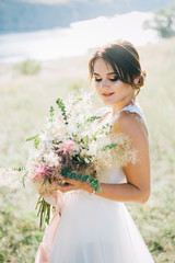 Bride in a luxurious white wedding dress in nature at sunset	