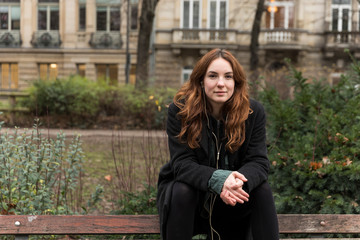 Young Woman Looking at Camera Seated on Bench