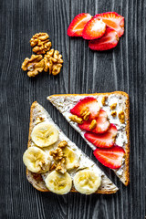 lunch with triangle sandwiches on dark table background top view