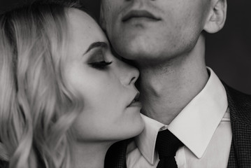 Cute wedding couple in the interior of a classic studio decorated. They kiss and hug each other.