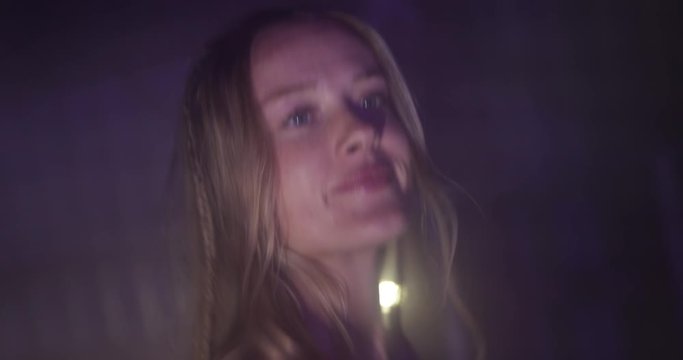  young caucasien girl dancing in nightclub with blinking lights and smoke in slow motion