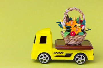 toy truck delivering a basket with flowers. Gifts with home delivery concept.