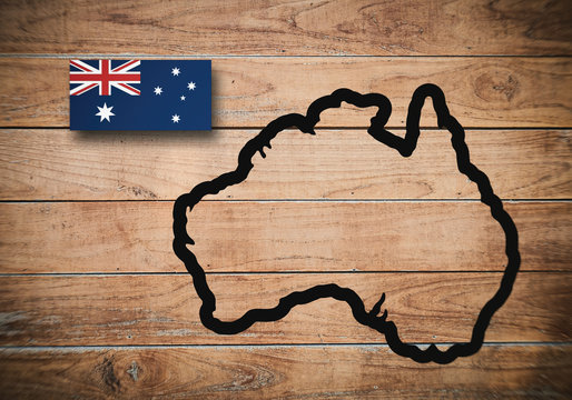 Flag and map of Australia on a dirty wooden background.