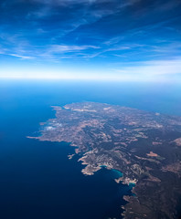 The Earth can be seen from the aircraft's porthole at high altitude. view from the porthole to the outlines of the island of Mallorca. View of the earth from a great height. Image with selective focus