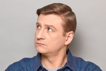 Naklejka premium Portrait of blond mature man with neutral expression on face