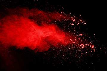 Explosion of red powder on black background.