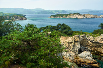 Fototapeta na wymiar High cliffs in the ocean. Rocky islands and rocks in Orlik Bay in the Sea of Japan. Far East.