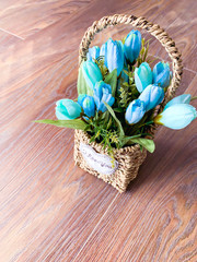 Basket with blue spring flowers. Spring bouquet with a declaration of love.