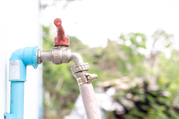 Faucet old red plumbing. Brass water tap in nature background. Water valve in the garden.