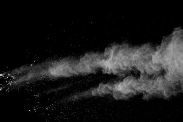 Freeze motion of white color powder exploding on black background.
