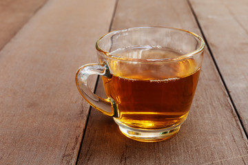 Close up hot tea cup on wood table . hot tea in handle glass with copy space for text or design.