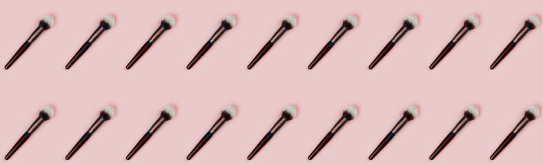 Cosmetic makeup brush on pink color background, top view pattern