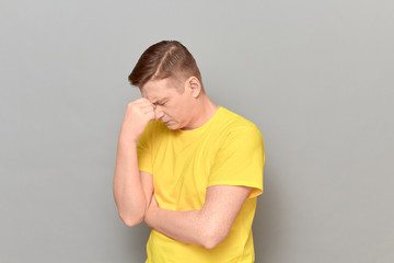 Portrait of thoughtful tired mature man touching bridge of his nose