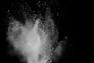 Freeze motion of white color powder exploding on black background.