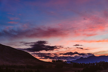 Sonnenuntergang bei Landschaft mit Hügeln in Neuseeland