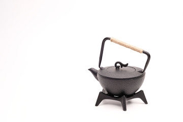 Black metal cast-iron traditional teapot on white background.