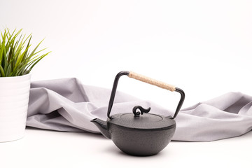 Black metal cast-iron teapot on a white background.