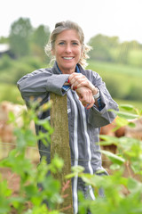 Portrait of a smiling cattlewoman standing beside her cows