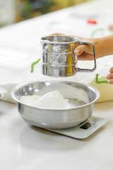 Cooking Baking. Cook sifts the flour close up