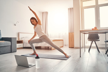 Attractive young female person doing stretching exercise