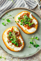 Canape or crostini with toasted baguette, cottage cheese, fig jam