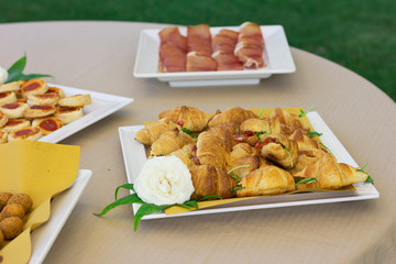 Snacks on the wedding table. Croissants, cold cuts. Outdoor wedding.