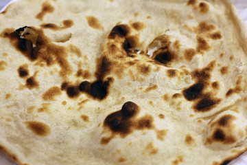 Closeup of a naan bread - buttery, white bread often eating with dips. Indian style street food from a food court in a mall located in Dubai. Delicious yet not too healthy food. Color closeup image.