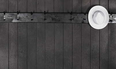 hat on a black wooden hanger on a black wooden wall