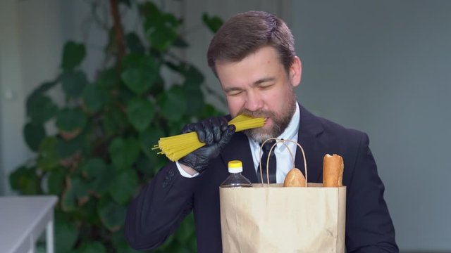 Businessman in black gloves eats raw spaghetti