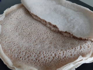 Asmara, Eritrea - 08/05/2020: Ethiopian and Eritrean food, assortment of main dishes. Injera is a sourdough flatbread made from teff flour. It is the national dish of Ethiopia, Eritrea.