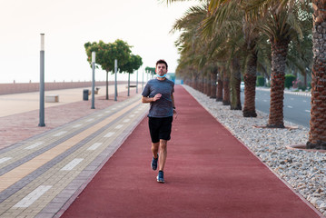 Man jogging on the running track wearing protective mask