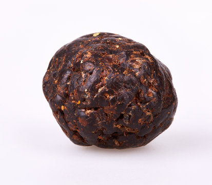 ee Propolis is formed into  ball on a white background. The bee propolis is shaped into spherical shape, close up