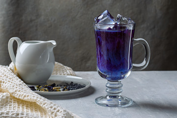 Iced tea Matcha Blue Latte, matcha in a glass cup on a light gray background. Horizontal orientation
