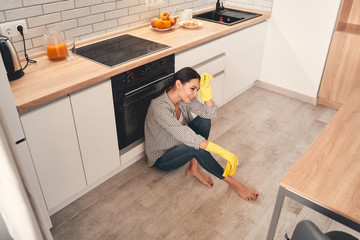 Tired young woman being deep in thoughts