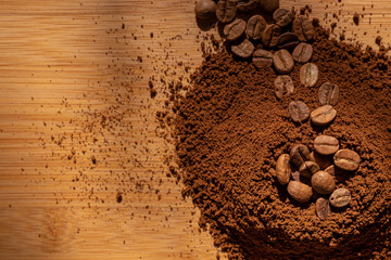 Top view of coffee beans and ground coffee on wooden background, roasted coffee volcano like anthill