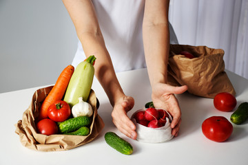 Humans hands unpack fresh vegetables off eco friendly packaging