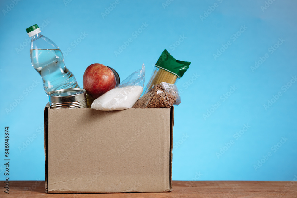 Wall mural Donation box with food isolated on white background. Close up of different food in a volunteer box. Donate Box, donation and charity concept.