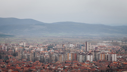 Hazy sky over desaturated Pirot cityscape, view from a vantage point 