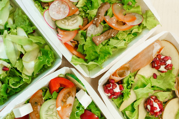 Green natural salads in eco thermo box with microgreen, veal, cucumber, tomato, cheese. Safety delivery at quarantine covid 19. On line order from the restaurant delivered to people who stay at home
