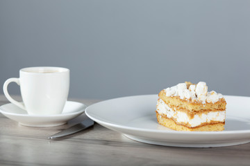 cake on the plate and cup of coffee with lilac