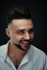 Portrait of handsome young man against studio background. Perfect hairstyle, modern stylish haircut. Attractive guy with fashion hairstyle. Confident man with short beard. Barbershop concept.